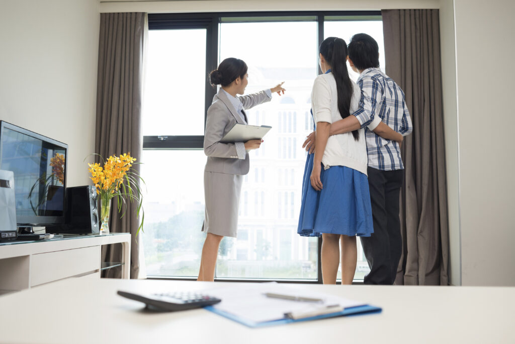Estate broker showing married couple the view from the apartment window