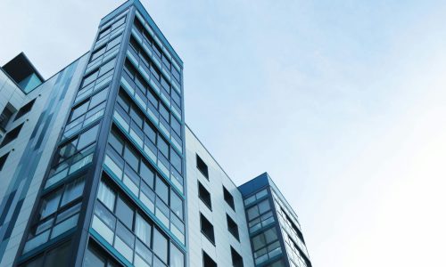 Low-angle view of a modern glass skyscraper against a clear sky in Poole, UK.